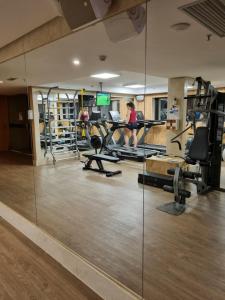 a gym with treadmills and people in the background at Cullinan apart-hotel particular in Brasília