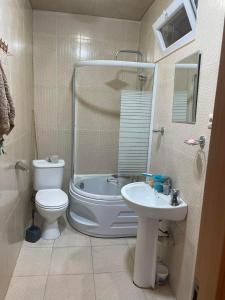 uma casa de banho com um WC, uma banheira e um lavatório. em Guest house gio em Kobuleti