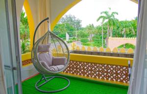 una silla colgante en un balcón con ventana en Luxury 2 bedroom, en Ukunda