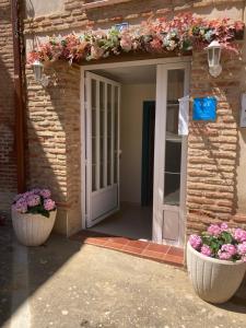 una entrada a un edificio con dos grandes macetas de flores en El Encanto de un pueblo mini, 