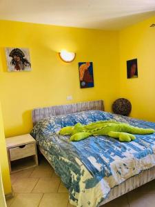 a bedroom with a bed with a large green object on it at Casa Laranja Santa Maria in Santa Maria