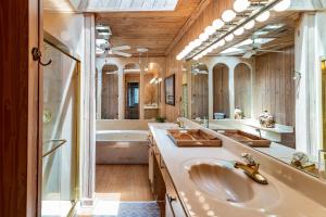 ein Badezimmer mit zwei Waschbecken, einer Badewanne und einem Spiegel in der Unterkunft 4 Bedroom Retreat with Game Room and Creek Access in Pawleys Island