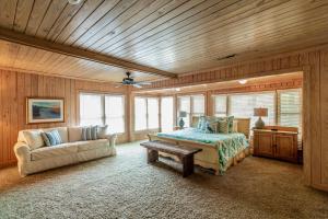 ein Schlafzimmer mit einem Sofa und einem Bett in einem Zimmer in der Unterkunft 4 Bedroom Retreat with Game Room and Creek Access in Pawleys Island