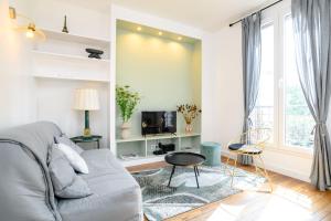 ein Wohnzimmer mit einem Sofa und einem TV in der Unterkunft The Parisian Stay - Duke Housing in Vitry-sur-Seine