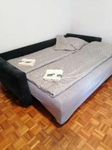 a bed with two pillows on it on a wooden floor at Sarajevo stan in Sarajevo