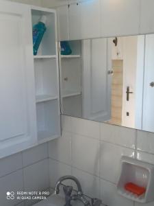 a bathroom with white cabinets and a sink and a mirror at Θέρετρο Γαλάζιου Ουρανού in Athens