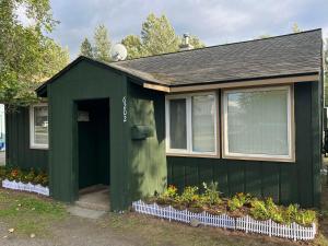 a green shed with flowers in front of it at Nunaka Valley Cottage in Anchorage