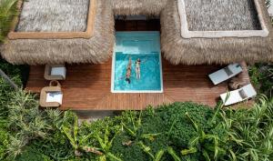 an aerial view of two people swimming in a swimming pool at Sensations Eco-Chic Hotel in Pwani Mchangani Mdogo