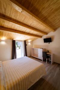 a bedroom with a bed and a desk and a television at Agriturismo Bio Podere 109 in Alberese