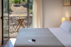 a bedroom with a bed and a patio with a table at Hotel Vilar Rural d'Arnes by Serhs Hotels in Arnés