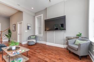 a living room with a couch and a tv at Historic Benton Park Townhome in Soulard