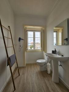 a bathroom with a sink and a toilet and a window at Maria Saudade Apartamento in Sintra