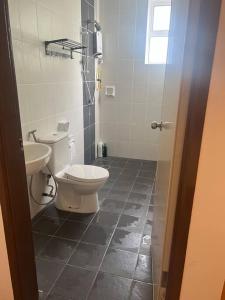 a bathroom with a toilet and a sink at Muji Wi-Fi Aircond HomeStay in Sandakan