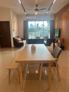 a wooden table and chairs in a living room at Muji Wi-Fi Aircond HomeStay in Sandakan