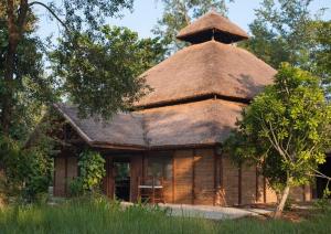 an old house with a thatched roof at Tiger Tops Karnali Lodge in Bardia