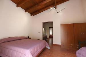 um quarto com uma cama rosa e um tecto de madeira em Aretusa Girgenti Home em Agrigento