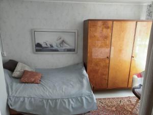 1 dormitorio con 1 cama y armario de madera en Lossi 8 Põltsamaa Lonny jõevaatega, en Põltsamaa