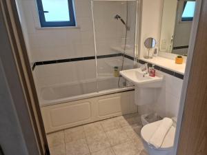 uma casa de banho com um chuveiro, um WC e um lavatório. em Immaculate 1-Bed Apartment in London em Londres