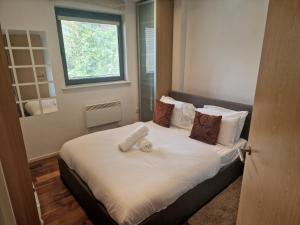 um quarto com uma cama com lençóis brancos e uma janela em Immaculate 1-Bed Apartment in London em Londres
