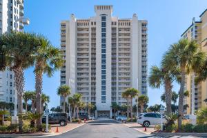 ナバーにあるSunsational Pearl of the Seaのヤシの木が前に立つ大きな白い建物