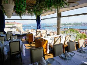 a restaurant with tables and chairs and a large window at Cihangir Residences in Istanbul