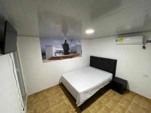 Apartahotel Saroa في Fonseca: غرفة صغيرة بها سرير و لوحة على الحائط