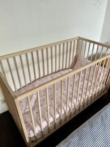 - un lit bébé dans une chambre avec un matelas rose dans l'établissement Lichtdurchflutete große Wohnung, à Schwelm