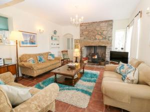 a living room with two couches and a fireplace at Gorphwysfa in Beaumaris