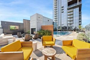 a rooftop patio with yellow furniture and a pool at NEW 1BR Scenic Retreat with Rooftop pool on Rainey St in Austin