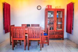 a dining room with a table and chairs and a clock at KJ Purple Gate SENGGIGI in Senggigi 