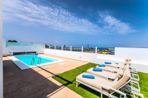 um pátio com espreguiçadeiras e uma piscina em 228 - Casa Luca by Villas Now Ltd em Playa Blanca