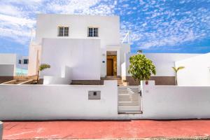 uma casa branca com uma escada em frente em 228 - Casa Luca by Villas Now Ltd em Playa Blanca