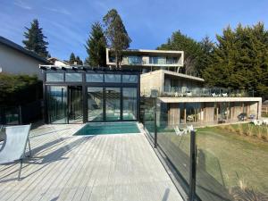 a house with glass doors and a swimming pool at Wa One Lake Homes in San Carlos de Bariloche