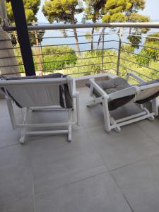a porch with a bed and a chair on a balcony at Mathesi Beachfront Apartment in Elia in Elia +42 photos
