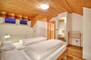 A bed or beds in a room at Chalet Lake View - by Alpen Apartments