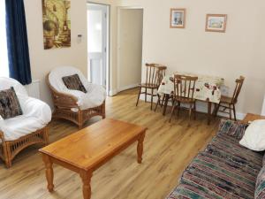 een woonkamer met een bank, stoelen en een tafel bij Daffodil Cottage in Grange