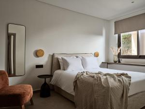 a bedroom with a bed and a chair and a mirror at Salita - Comfort Living Apartments in Zakynthos