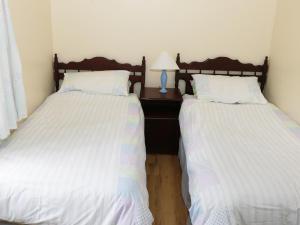 twee bedden naast elkaar in een slaapkamer bij Daffodil Cottage in Grange