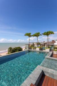 a swimming pool with a view of the beach at Arpoar Suítes by Slaviero Hotéis in João Pessoa