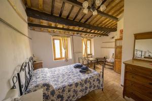 um quarto com uma cama, uma cómoda e um espelho em Agriturismo Il Cocco em Montalcino
