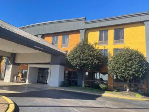 a yellow and orange building with trees in front of it at SureStay Hotel by Best Western Robinsonville Tunica in Tunica Resorts