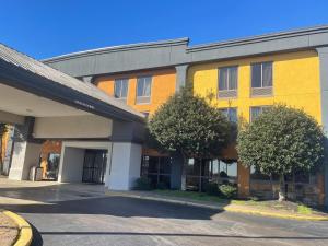 un edificio amarillo y naranja con árboles delante de él en SureStay Hotel by Best Western Robinsonville Tunica, en Robinsonville
