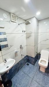 y baño con aseo y lavamanos. en EMERALD INN, en Kochi