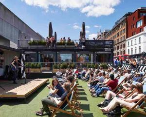 a crowd of people sitting in lawn chairs in a city at Luxe Prime 3 Beds Apartment in Central London in London