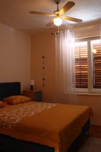 1 dormitorio con 1 cama y ventilador de techo en Platanus, en Trebinje
