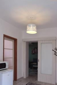 a kitchen with a light and a door with a microwave at Platanus in Trebinje +3 photos
