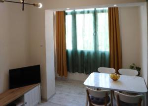 a living room with a table and chairs and a television at Platanus in Trebinje