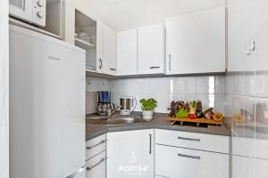 Una cocina blanca con gabinetes blancos y un fregadero. en Fördeblick, en Schausende