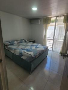 a bedroom with a bed in a room with a window at Casa Amoblada en Conjunto Cerrado in Villavicencio