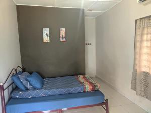 - une petite chambre avec un lit bleu dans l'établissement Mersing Chalet Teluk Sisek, 